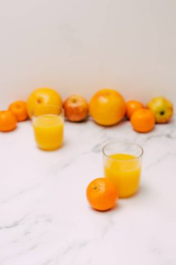 ışık tonlu mermer ve suyu gözlük, kavram ya da vitamin içme vs yemek ile sağlıklı meyve portakal greyfurt ve elma gibi dağınık