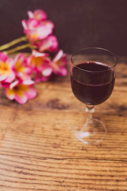 cam yoğun renkli kırmızı şarap ve ahşap masa, zarif ya da pahalı şarap seçimler kavramı üzerinde Avustralya tropik çiçekler