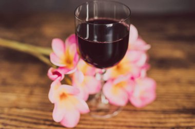 cam yoğun renkli kırmızı şarap ve ahşap masa, zarif ya da pahalı şarap seçimler kavramı üzerinde Avustralya tropik çiçekler