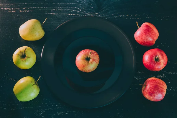 One Apple Black Plate Dark Background Others Both Green Red — Stock Photo, Image