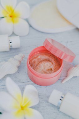 Spa fırçalayın vücut losyonları çevrili çiçekler ve açık renkli ahşap üzerine deniz kabuklarını, lüks ve doğal ürünler kavramı tarafından dizi ilham