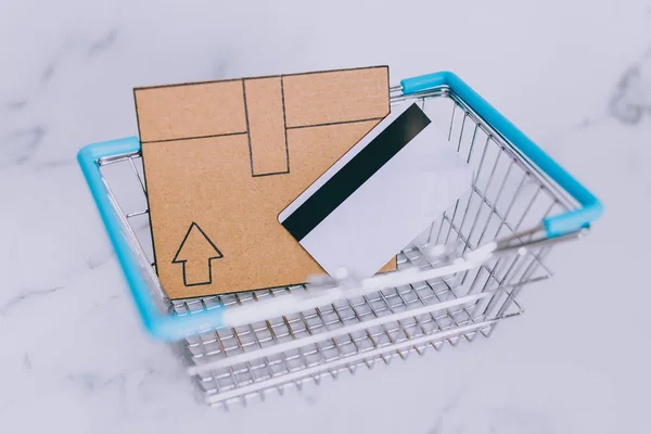 购物篮中的支付卡和迷你纸板送货图标 订购和接收您的购买的概念 — 图库照片
