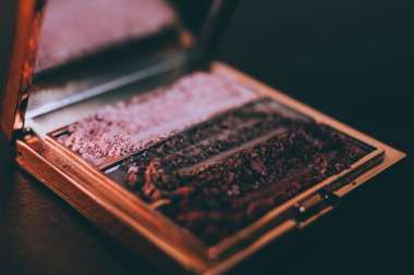 Palet ezilmiş toz kaptırdın koyu arka plan, güzellik ve makyaj trendleri kavramı üzerinde çıplak ve allık sesleri ile