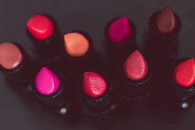 pembe ve çıplak kırmızı rujları farklı renkler ve dokular karanlık tablo, alan sığ derinliği ile ateş yakın çekim grup