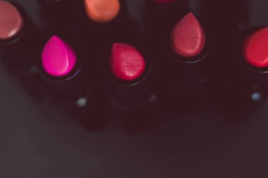 pembe ve çıplak kırmızı rujları farklı renkler ve dokular karanlık tablo, alan sığ derinliği ile ateş yakın çekim grup