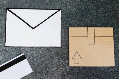 e-posta zarf ve ödeme kartı beton masa, nakliye ve online Gönderileriniz izleme kavramı üzerine Karton Koli