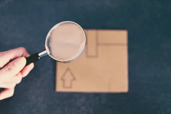 Cardboard Parcel Hand Holding Magnifying Glass Concrete Desk Concept Shipping — Stock Photo, Image