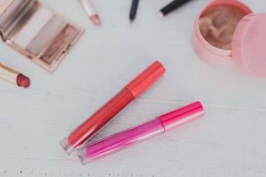 renkli lipglosses diğer kalıcı makyaj ürünleri ahşap masa, güzellik sektörünün kavramı üzerinde çevrili