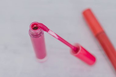 pembe ve turuncu lipglosses veya sıvı hafif ahşap masa, güzellik sektörünün kavramı ruja Close-Up
