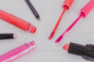 renkli lipglosses diğer kalıcı makyaj ürünleri ahşap masa, güzellik sektörünün kavramı üzerinde çevrili