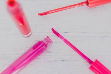 pembe ve turuncu lipglosses veya sıvı hafif ahşap masa, güzellik sektörünün kavramı ruja Close-Up