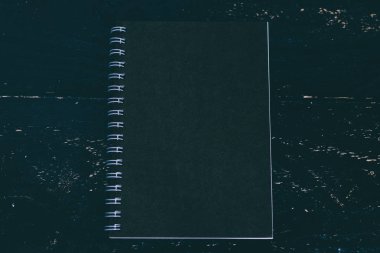 siyah ahşap masa üzerinde siyah defter