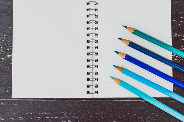 Bureau avec bloc-notes et crayons de couleur avec pages vides et flic — Photo