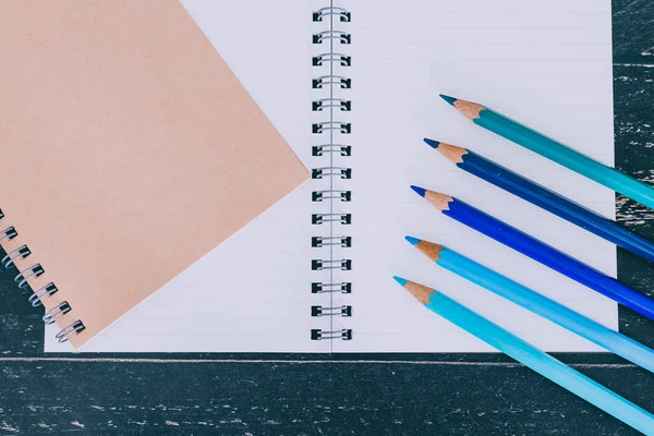 Bureau avec bloc-notes et crayons de couleur avec pages vides et flic — Photo