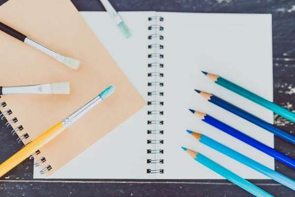 Stůl s bloky a akvarel štětce a barevné tužky wi — Stock fotografie