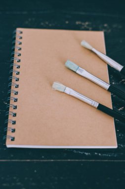 masa üstüne not defteri ve suluboya fırça ile