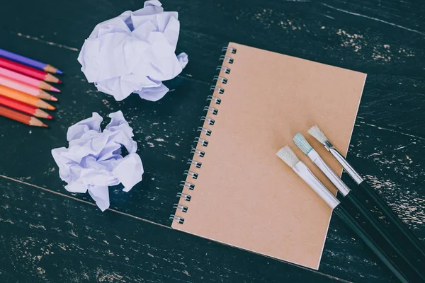 Escrivaninha com materiais de arte mista, incluindo cadernos de lápis coloridos — Fotografia de Stock