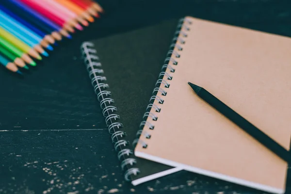 Escritorio con materiales de arte mixto incluyendo lápices de colores bloc de notas —  Fotos de Stock