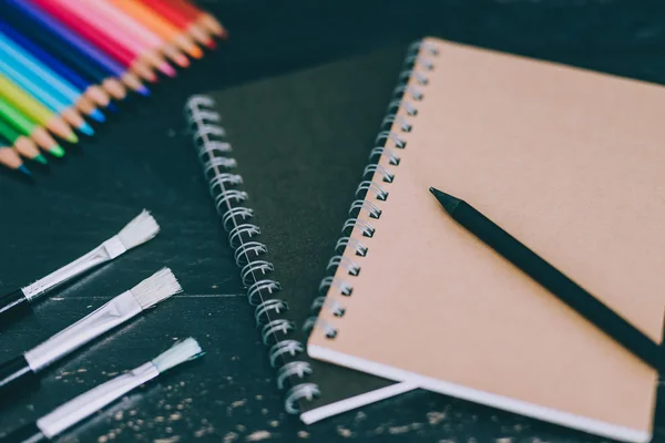 Escrivaninha com materiais de arte mista, incluindo cadernos de lápis coloridos — Fotografia de Stock