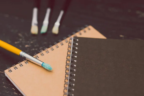 Escrivaninha com blocos de notas e pincéis de aquarela — Fotografia de Stock