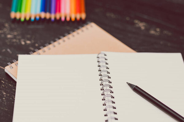 notebooks with colorful pencils and art supplies