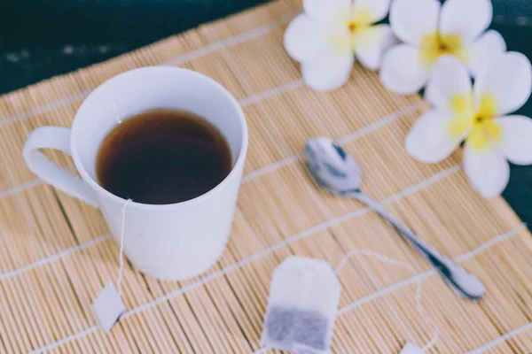 スプーンと花竹マットに濃いお茶すべて ar — ストック写真