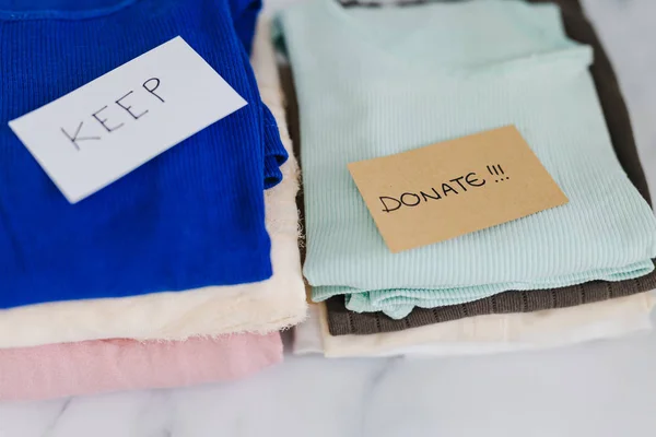 Pilhas de camisetas e roupas que estão sendo classificados em manter descarte e — Fotografia de Stock