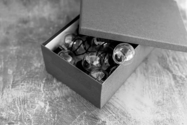 Open doos met miniatuur gloeilamp die eruit gaat — Stockfoto