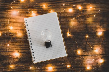 yeni fikirler için zaman Notebook ve ampul surrounde ile yatık