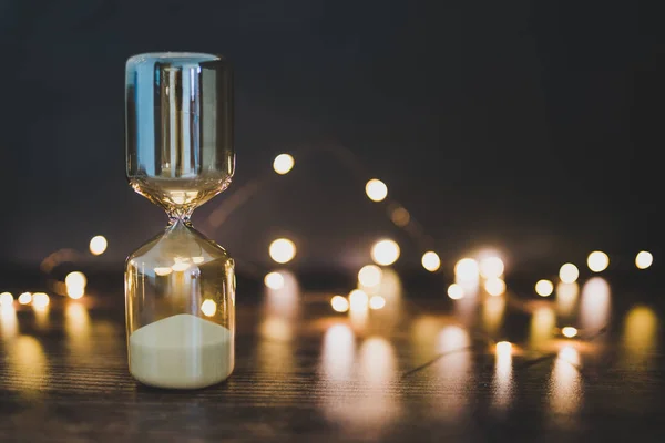 time management hourglass surrounded by fairy lights bokeh