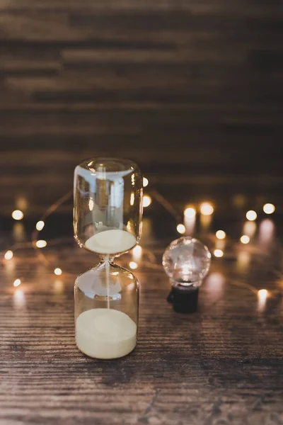 time for new ideas hourglass and lightbulb surrounded by fairy l