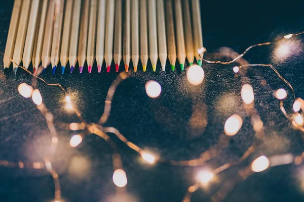 Set of coloured pencils on desk with fairy lights shot at shallo — Stock Photo, Image
