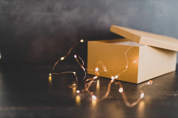 open mystery box or parcel with fairy lights popping out