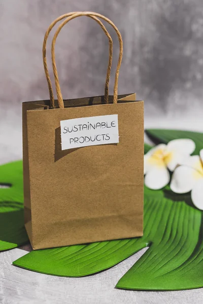 paper shopping bag with Sustainable Item label on it on leaf and
