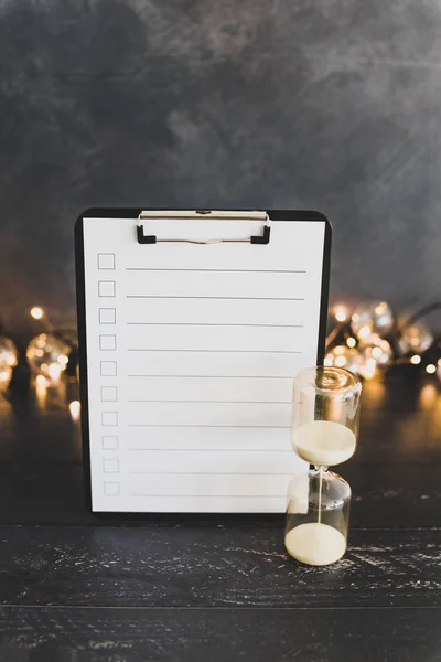 clipboard with blank list with cases to tick off on wooden desk