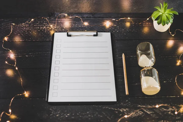 clipboard with blank list with cases to tick off on wooden desk