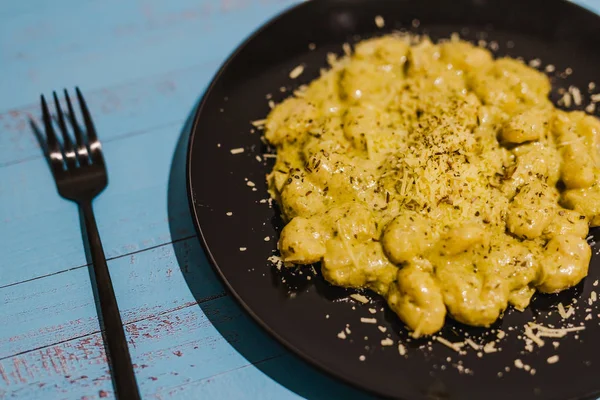 creamy gnocchi with parmesan and herbs served on teal plate