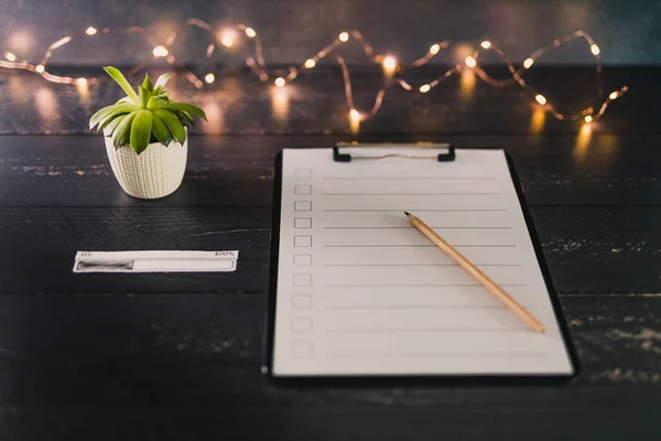 clipboard with blank list with cases to tick off on wooden desk