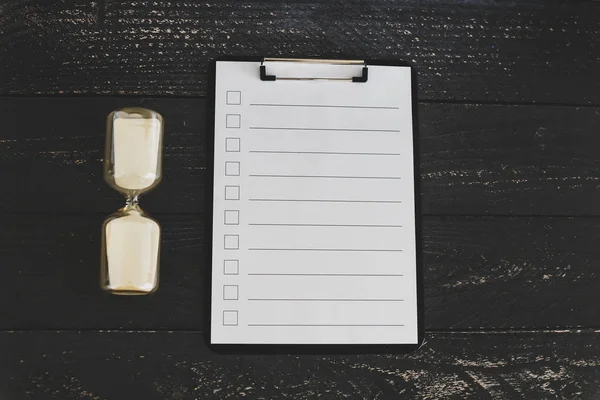 clipboard with blank list with cases to tick off on wooden desk