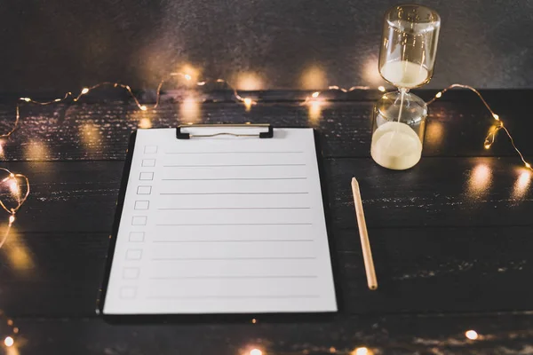 clipboard with blank list with cases to tick off on wooden desk