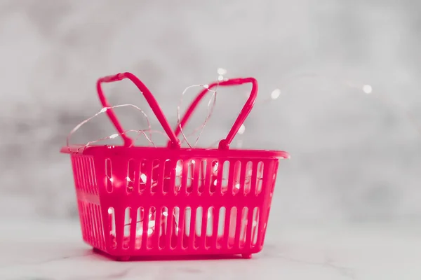 Cesta de la compra de color rosa con luces de hadas para la comercialización brillante o —  Fotos de Stock