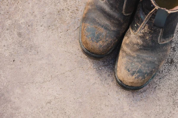 Beton zemin üzerinde yıpranmış iş botları, sıkı çalışma kavramı — Stok fotoğraf