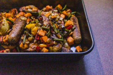 vegan sosis patates ve karışık kavrulmuş veggi ile fırın tepsisi