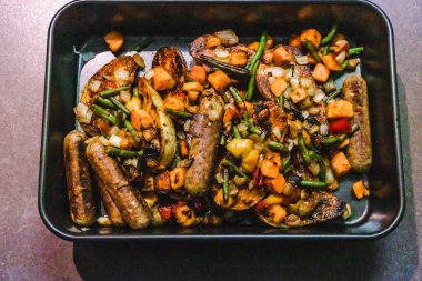 vegan sosis patates ve karışık kavrulmuş veggi ile fırın tepsisi
