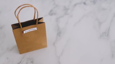 el başka bir çanta işaretli Alışveriş, minimalist yaşam tarzı kavramı yanında mermer masaya Kasıtlı Alışveriş etiketli çanta yerleştirerek