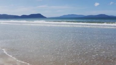 Tazmanya kıyıları boyunca Marion Körfezi'nde bozulmamış ıssız plaj, güneş parlayan ve Güney Pasifik Okyanusu dalgaları ile hiçbir kişi ile deniz esintisi haddeleme