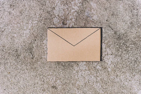 在混凝土背景上用纸板制成的电子邮件信封标志 — 图库照片