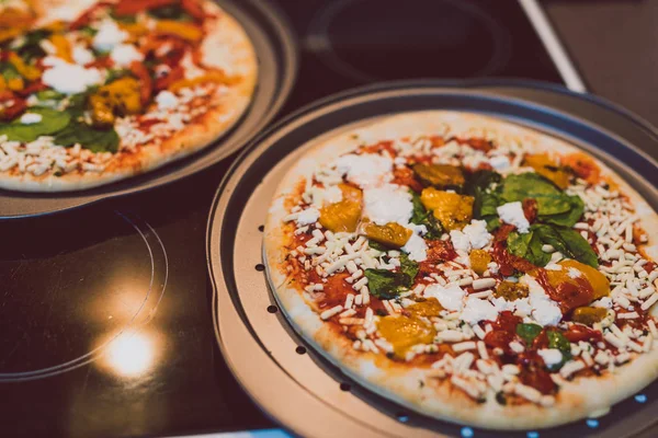 Frozen vegetarian pizzas on stove about to be cooked in the oven — Stock Photo, Image