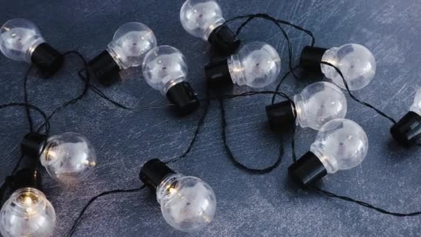 一组灯泡形状的串灯闪耀在黑暗的办公桌暗示发明和好的想法 相机水平平移 — 图库视频影像