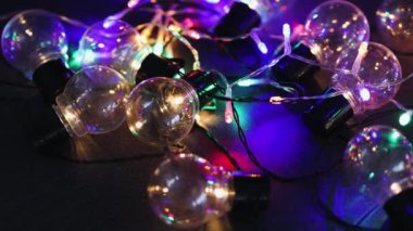 büyüteç analiz (en iyi fikir değerlendirme metaforu), kamera yatay kaydırma ile karanlık masada parlayan başkalarının grup önünde izole bir benzersiz ampul